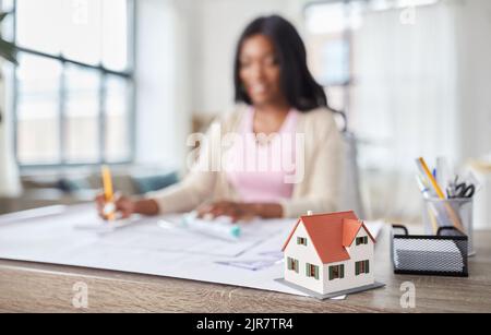 modello di casa e architetto femminile che lavora in ufficio Foto Stock