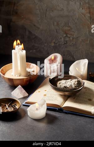 libro magico, salvia, candele bruciate e personale rituale Foto Stock