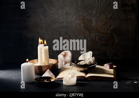 libro magico, salvia, candele bruciate e personale rituale Foto Stock