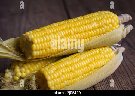 pannocchie di mais mature cotte al vapore o bollite per una cena vegana o uno spuntino, mais dolce cotto su sfondo di legno Foto Stock