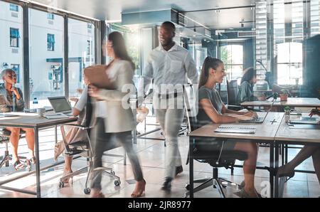 Ufficio impegnato con un team produttivo di dipendenti che lavorano sodo e velocemente per completare attività e progetti. Colleghi, colleghi o uomini d'affari in un Foto Stock