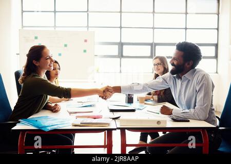 Dobbiamo unirci per creare più insieme: Lavoratori creativi che si riuniscono in un ufficio moderno. Foto Stock