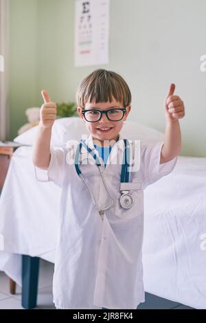 Vedo i medici come modelli di ruolo, un adorabile ragazzino vestito da medico. Foto Stock