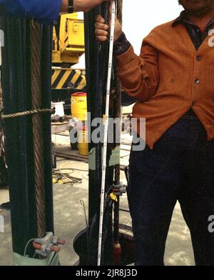 A770918 U7AP CREWLINE DOWNHOLE OPERATIONS JOHN BROUILLARD (PROJECT ENGINEER) MAY 12 77 EG&G/NTS PHOTO LAB PUBLICATION DATE: 5/12/1977 BROUILLARD, JOHN; CABLES (NON ELECTRIC COMPANY); CREWLINE; CREWLINE TEST; DOWNHOLE OPERATION; EDGERTON, GERMESHAUSEN & GRIER; EG&G; APPARECCHIATURE E STRUMENTI; STRUMENTI E ATTREZZATURE; MASCHIO; UOMINI (AGGIUNGERE MODIFICATORE MASCHILE); NEVADA; NEVADA TEST SITE; NTS; TECNOLOGIA NUCLEARE; PROVE NUCLEARI; CAVI SLIFER; MISURE A NASTRO; SITI DI PROVA; UGT; TEST IN SOTTOSUOLO; FILI E CAVI; IMMAGINI STORICHE DELLE OPERAZIONI CREWLINE-DOWNHOLE. 1972 - 2012. Dipartimento di energia. Nazionale N Foto Stock