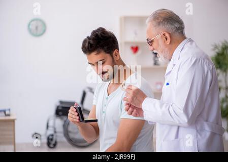 Giovane paziente con problemi di udito visita dottore otorinolaringologo Foto Stock