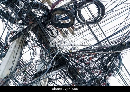 Fili elettrici aggrovigliati sul polo elettrico urbano. Disorganizzato e disordinato per il concetto di gestione dell'organizzazione. Primo piano fili elettrici aggrovigliati Foto Stock