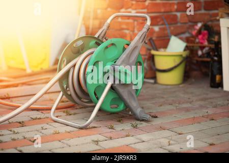 Avvolgitubo da giardino su un pavimento. Foto di alta qualità Foto Stock