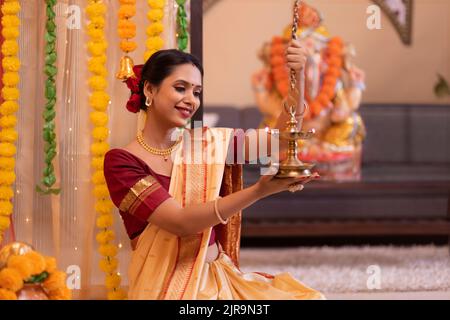 Ritratto di donna Maharashtria in abito tradizionale con lampada ad olio in occasione di Ganesh Chaturthi Foto Stock