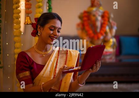 Ritratto di una felice donna Maharashtrian in abito tradizionale con una scatola di gioielli in occasione di Ganesh Chaturthi Foto Stock