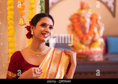 Ritratto di una allegra donna maharashtria in abito tradizionale guardando altrove in occasione di Ganesh Chaturthi Foto Stock