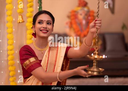 Ritratto di donna Maharashtria in abito tradizionale con lampada ad olio in occasione di Ganesh Chaturthi Foto Stock