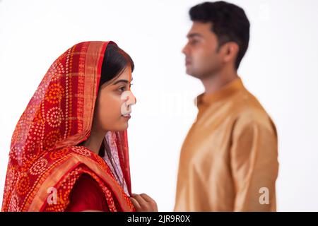 Sposa e sposo dopo il matrimonio suo marito è in piedi dietro, in un tradizionale matrimonio Bihari Foto Stock