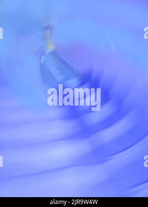 Lungo tunnel in cemento con lanterne di fondo fuori fuoco. Sottopassaggio con un sentiero senza sfondo sfocato. Foto Stock