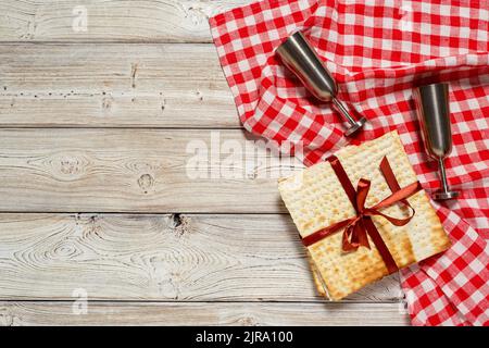 Festa ebraica della Pasqua design banner con vino, matzo su sfondo di legno. Foto Stock