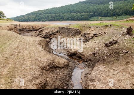 La foto mostra il sito del villaggio perduto che ora può essere visto. Il serbatoio di Ladybower durante il tempo secco e la siccità nell'estate del 2022. Ladybower Reservoir è un grande serbatoio artificiale a forma di Y, il più basso dei tre nella Upper Derwent Valley nel Derbyshire, Inghilterra. Foto Stock