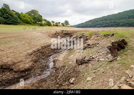 La foto mostra il sito del villaggio perduto che ora può essere visto. Il serbatoio di Ladybower durante il tempo secco e la siccità nell'estate del 2022. Ladybower Reservoir è un grande serbatoio artificiale a forma di Y, il più basso dei tre nella Upper Derwent Valley nel Derbyshire, Inghilterra. Foto Stock