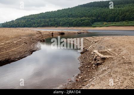 La foto mostra il sito del villaggio perduto che ora può essere visto. Il serbatoio di Ladybower durante il tempo secco e la siccità nell'estate del 2022. Ladybower Reservoir è un grande serbatoio artificiale a forma di Y, il più basso dei tre nella Upper Derwent Valley nel Derbyshire, Inghilterra. Foto Stock