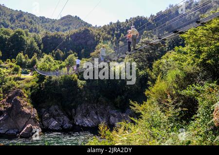 Traffico a due vie mentre i visitatori attraversano il ponte sospeso più lungo della Nuova Zelanda, sopra il fiume Buller, nel vicino Buller Gorge Adventure & Heritage Park Foto Stock