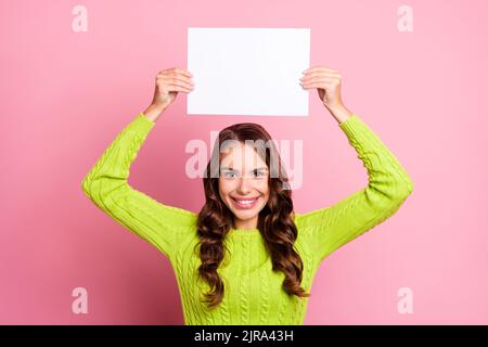 Foto di donna allegra riccia capelli alzano bianco copyspace banner indossare trendy verde maglia pullover isolato su sfondo di colore blu Foto Stock