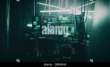 Dark hacker rifugio con lampade e tavoli e attrezzature informatiche con programmi per crimini informatici e attacchi informatici Foto Stock