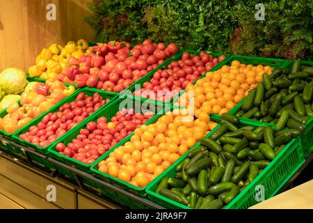 Supermercato verdure sfondo. Pomodori freschi e peperoni in scatole al banco del supermercato. Cibo, generi alimentari, concetto di agricoltura. Foto di alta qualità Foto Stock