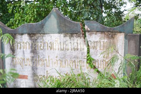 Un muro incrinato, con scritta thailandese su di esso, preso a Buriram, Thailandia. Foto Stock