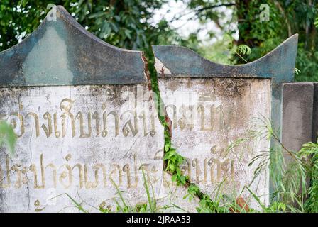 Un muro incrinato, con scritta thailandese su di esso, preso a Buriram, Thailandia. Foto Stock