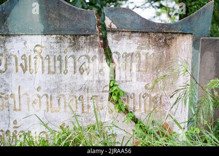 Un muro incrinato, con scritta thailandese su di esso, preso a Buriram, Thailandia. Foto Stock