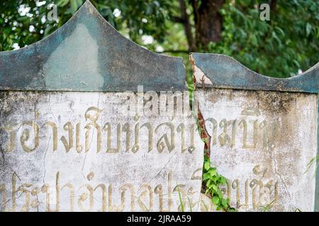 Un muro incrinato, con scritta thailandese su di esso, preso a Buriram, Thailandia. Foto Stock