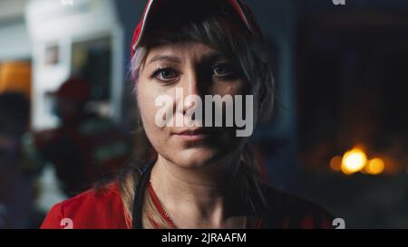 Calma e felice Donna EMS Professional Paramedic sorride sulla fotocamera in Ambulance Vehicle. Un tecnico medico di emergenza di successo che si è recato a una chiamata al di fuori dell'ospedale sanitario. Foto Stock