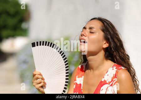 Donna che soffre colpo di calore in una strada cittadina in estate Foto Stock