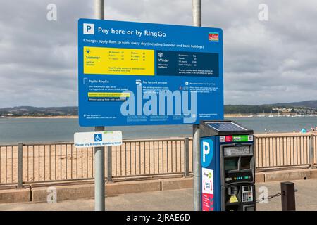 Un cartello per la tariffa del parcheggio sul lungomare di Exmouth Foto Stock