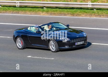 2006 ASTON MARTIN DB9 V12 5935cc 48V V12 6 Speed Sequential;' in movimento, in movimento, in guida, viaggiando sull'autostrada M6, Regno Unito Foto Stock