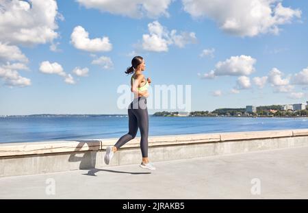 giovane donna che corre lungo il lungomare Foto Stock