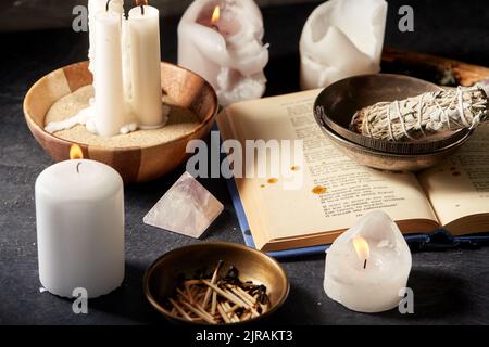 libro magico, salvia, candele bruciate e personale rituale Foto Stock