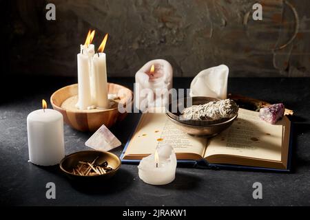 libro magico, salvia, candele bruciate e personale rituale Foto Stock