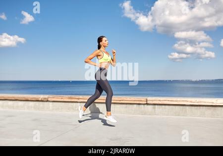 giovane donna che corre lungo il lungomare Foto Stock