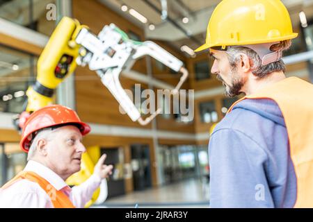 Collega senior in abbigliamento da lavoro che ha incontrato un lavoratore qualificato Foto Stock