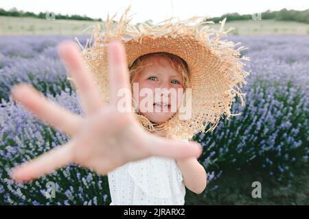 Ragazza triste che indossa cappello piangendo in campo di lavanda Foto Stock