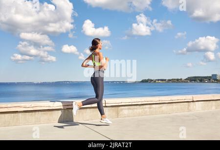 giovane donna che corre lungo il lungomare Foto Stock