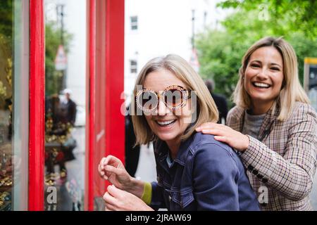 Donna anziana felice che indossa occhiali da sole da figlia Foto Stock