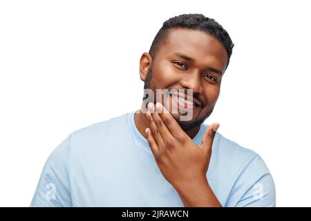 felice uomo afroamericano che tocca la barba Foto Stock