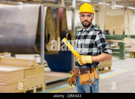 lavoratore maschile o costruttore in casco con livello Foto Stock