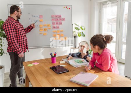 Insegnante che insegna inglese agli studenti a casa Foto Stock