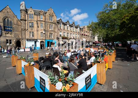 I turisti che mangiano in un ristorante all'aperto nel Grassmarket nel centro storico di Edimburgo, Scozia, Regno Unito Foto Stock