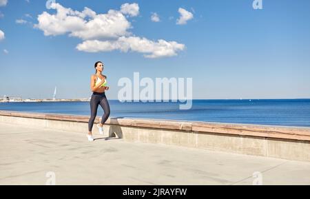 giovane donna che corre lungo il lungomare Foto Stock