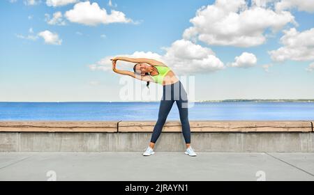 giovane donna che fa sport e stretching all'aperto Foto Stock