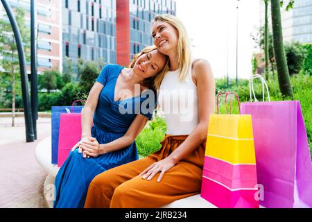 Donna che appoggia la testa sulla spalla dell'amico in città Foto Stock