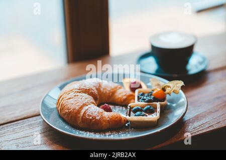 Croissant e caffè al tavolo Foto Stock