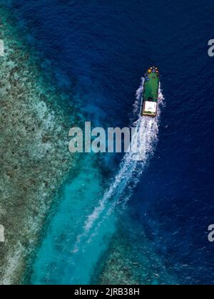 Maldive, Atollo Kaafu, Himmafushi, veduta aerea di motoscafo che naviga attraverso le acque costiere Foto Stock